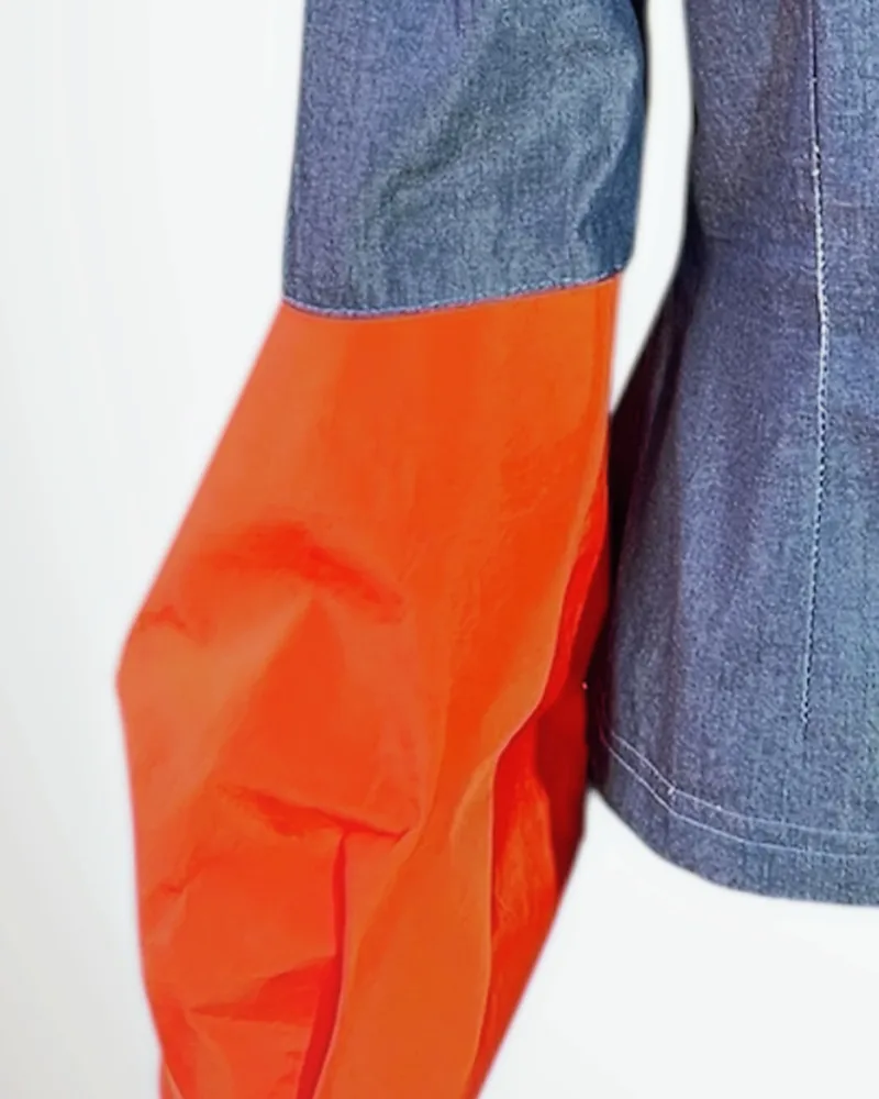 Detalle del tejido: Denim sostenible. Bocamanga en tafetán reciclado naranja.