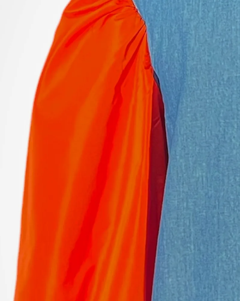 Detalle del tejido: Denim sostenible. Mangas globo en tafetán reciclado naranja.