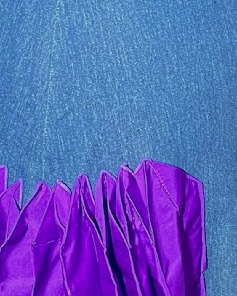 Detalle del tejido: Denim sostenible. Volúmenes laterales en tafetán morado.