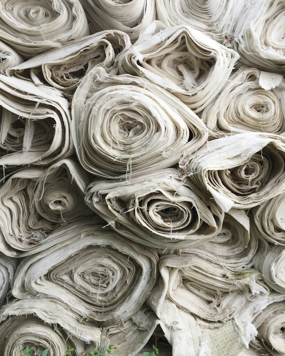 Rollos de tela cruda apilados en el taller